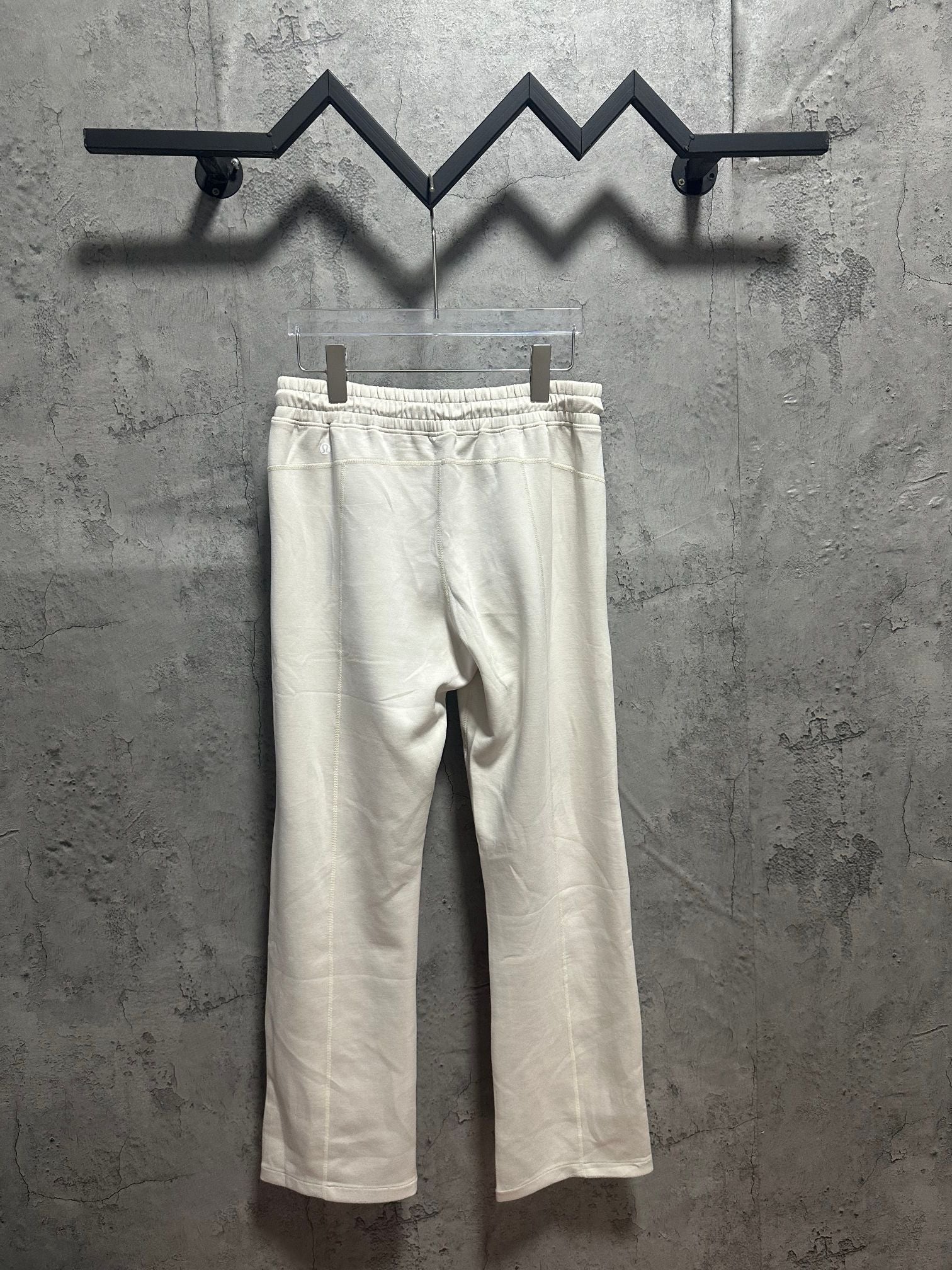 Cream jogger-style pants with elastic waist and straight leg opening