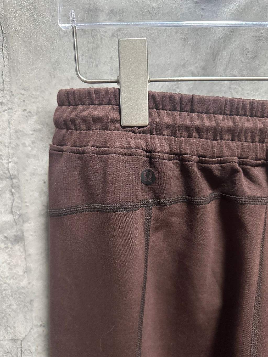 Maroon sweatpants close-up of elastic waistband with drawstring and seam