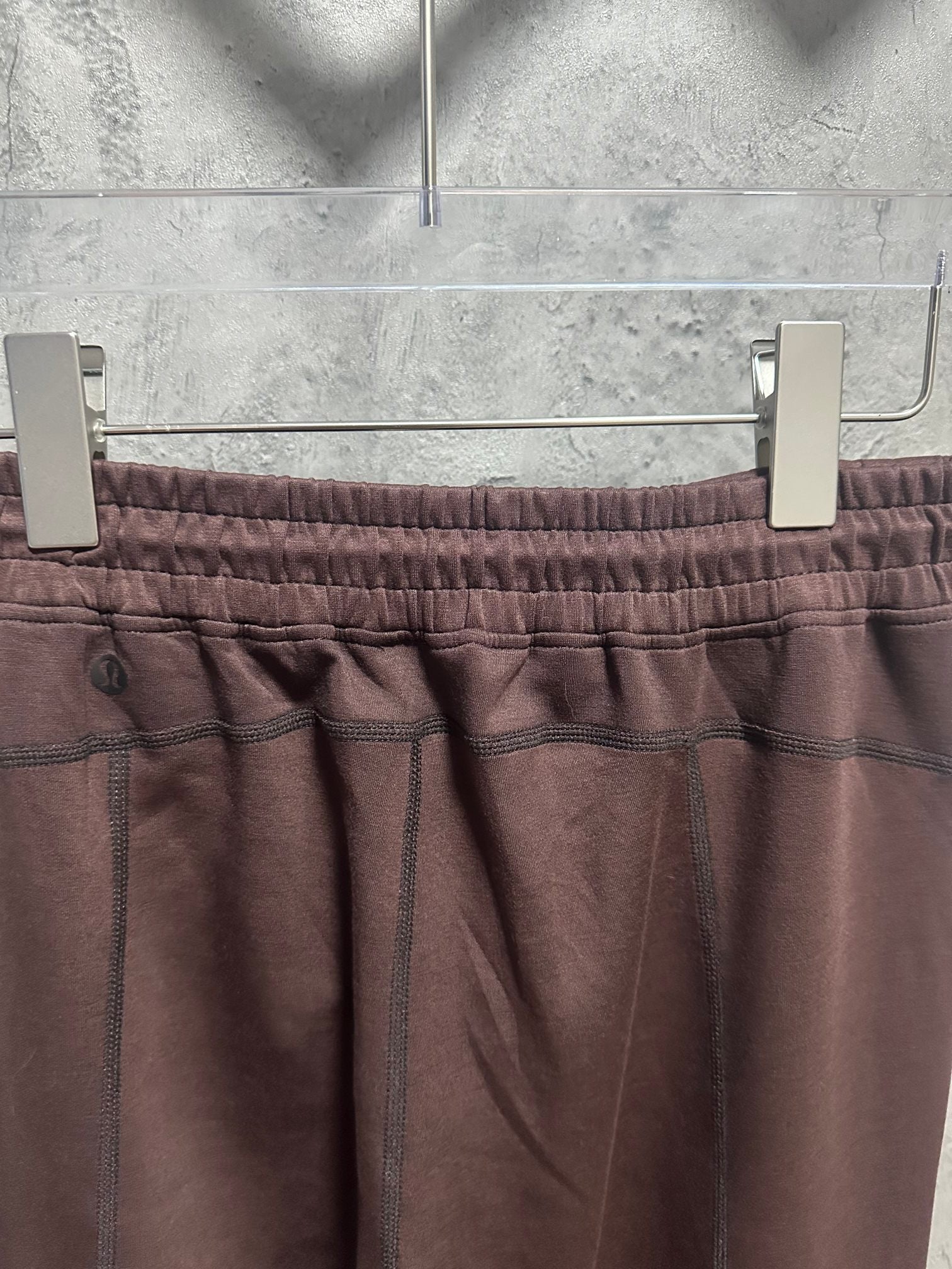 Maroon sweatpants with front pockets and elastic waistband stitching