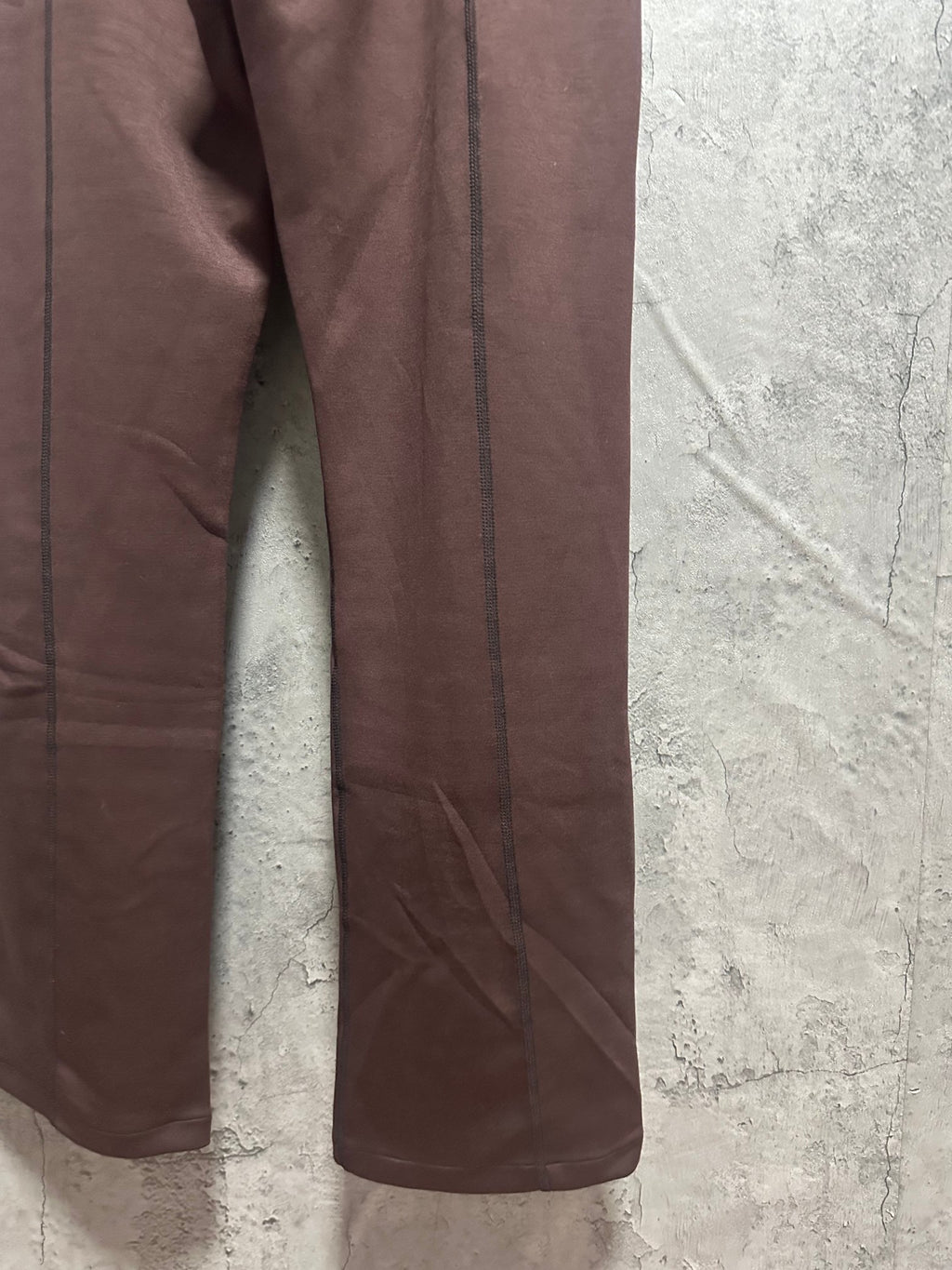 Maroon sweatpants leg close-up with side seam and relaxed fit