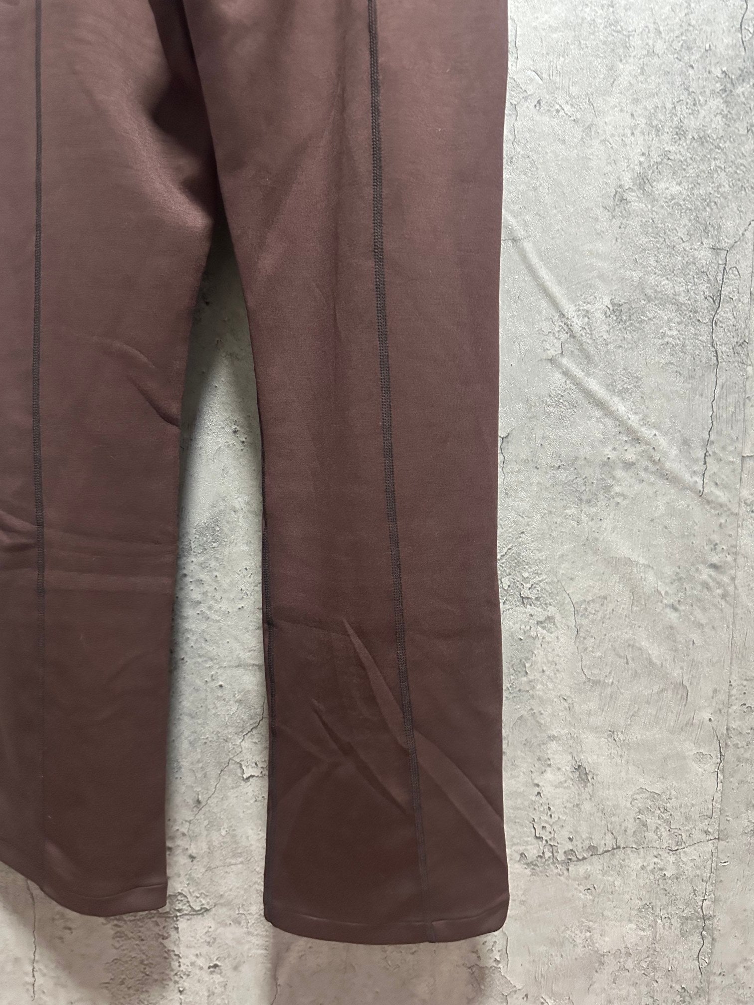 Maroon sweatpants leg close-up with side seam and relaxed fit