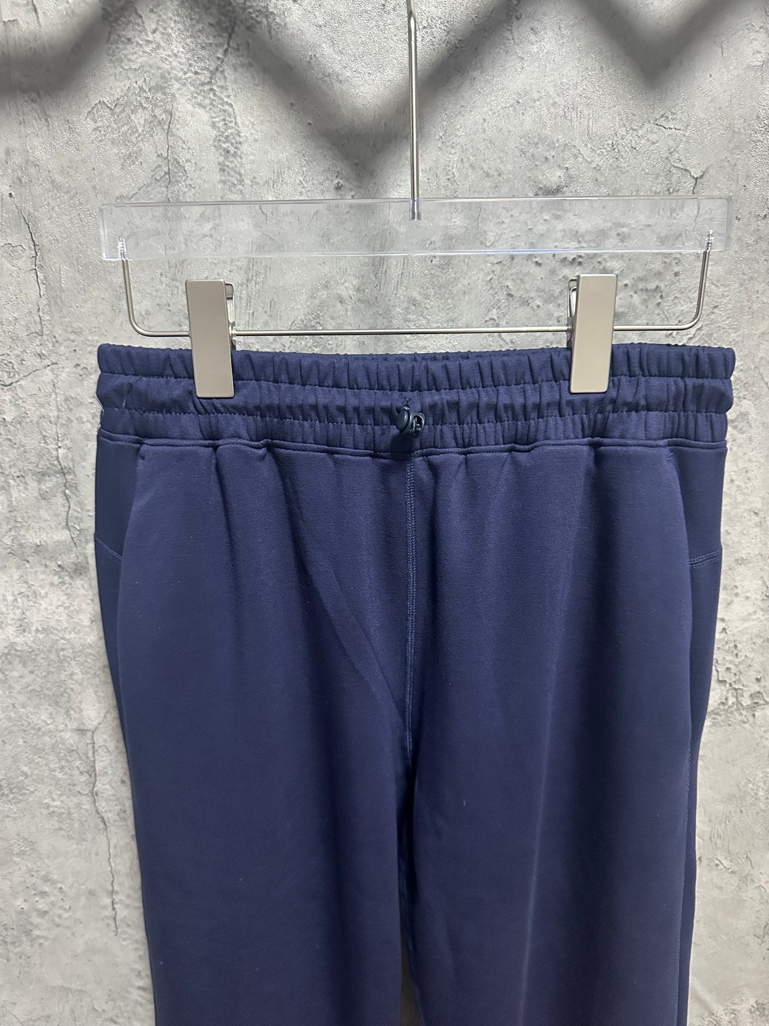 Navy trousers with elastic waistband, front pleats, and belt loops
