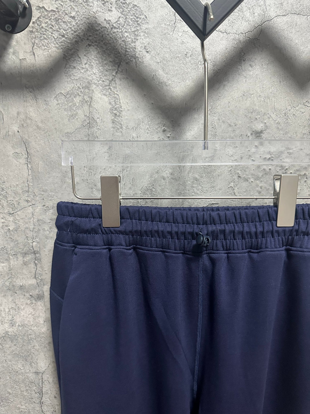 Navy pants with elastic waistband, small front button, and side pockets