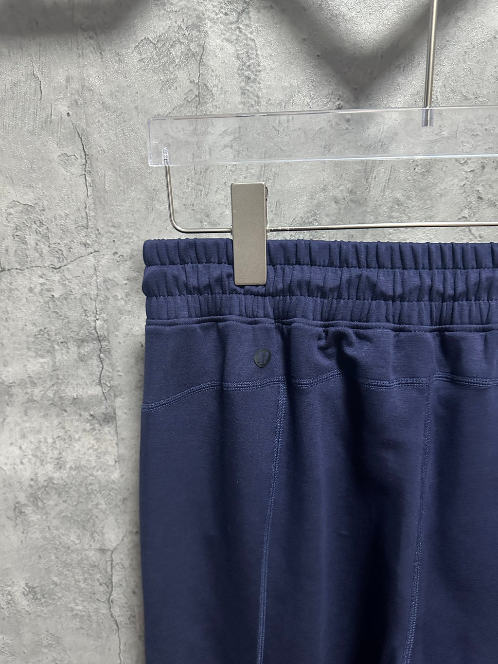 Navy trousers showing elastic waistband and center front button