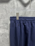 Navy trousers showing elastic waistband and center front button