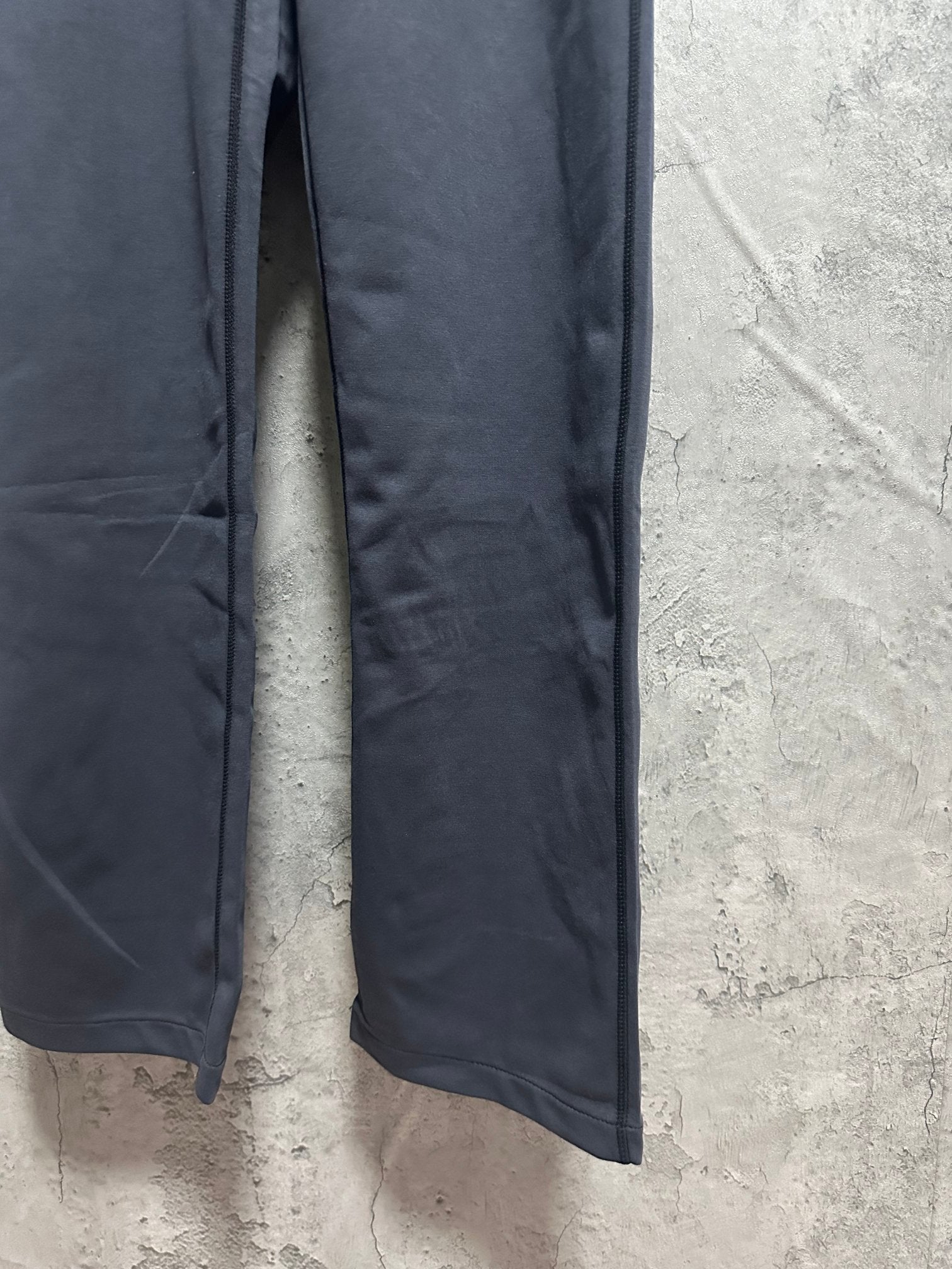 Dark blue sweatpants hem with side panels and subtle creasing