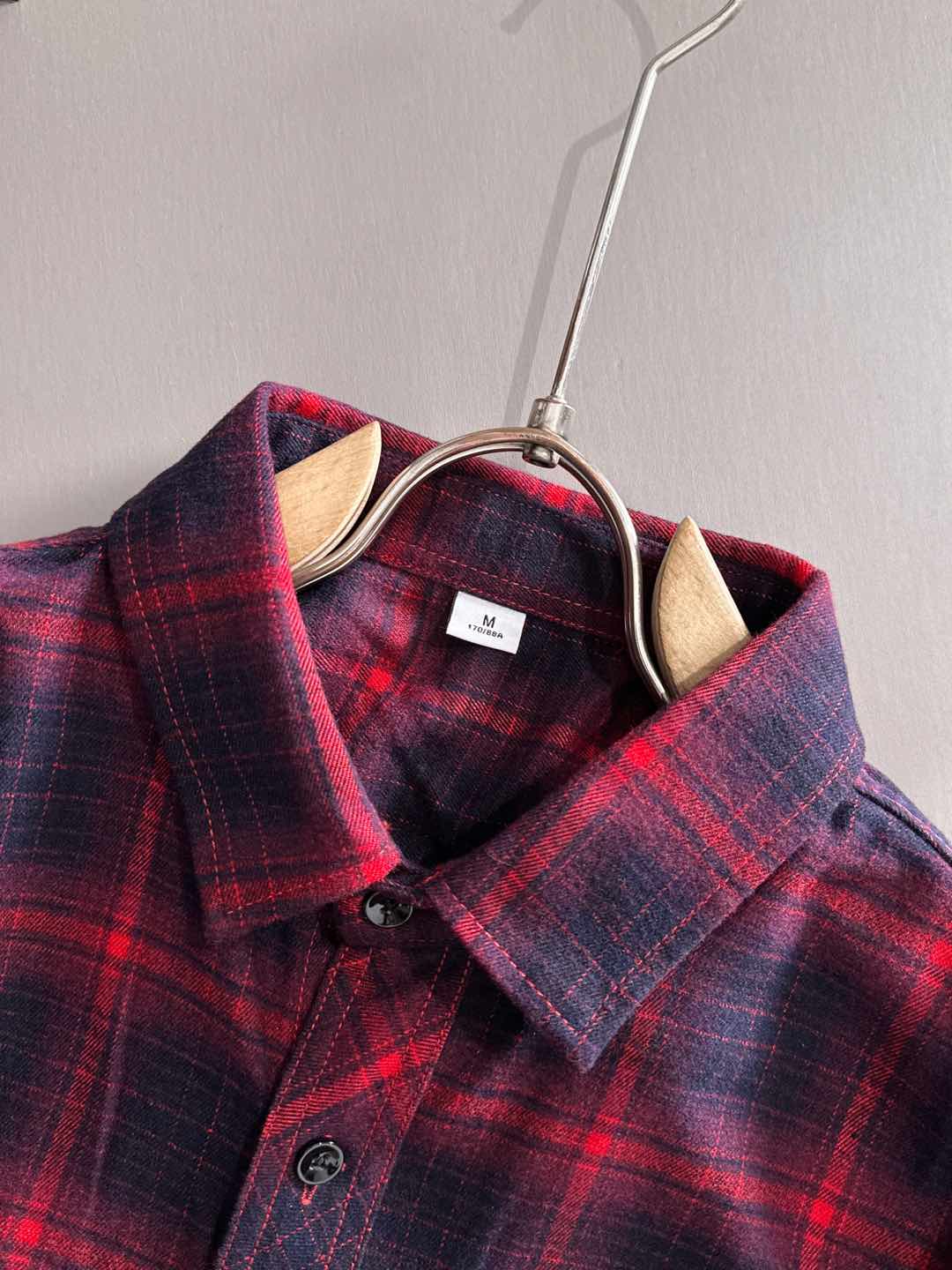 Long-sleeve plaid shirt neckline close-up with brand label and button placket