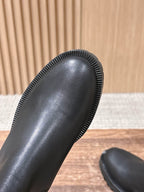 Close-up of black Chelsea boot toe and ribbed rubber outsole edge