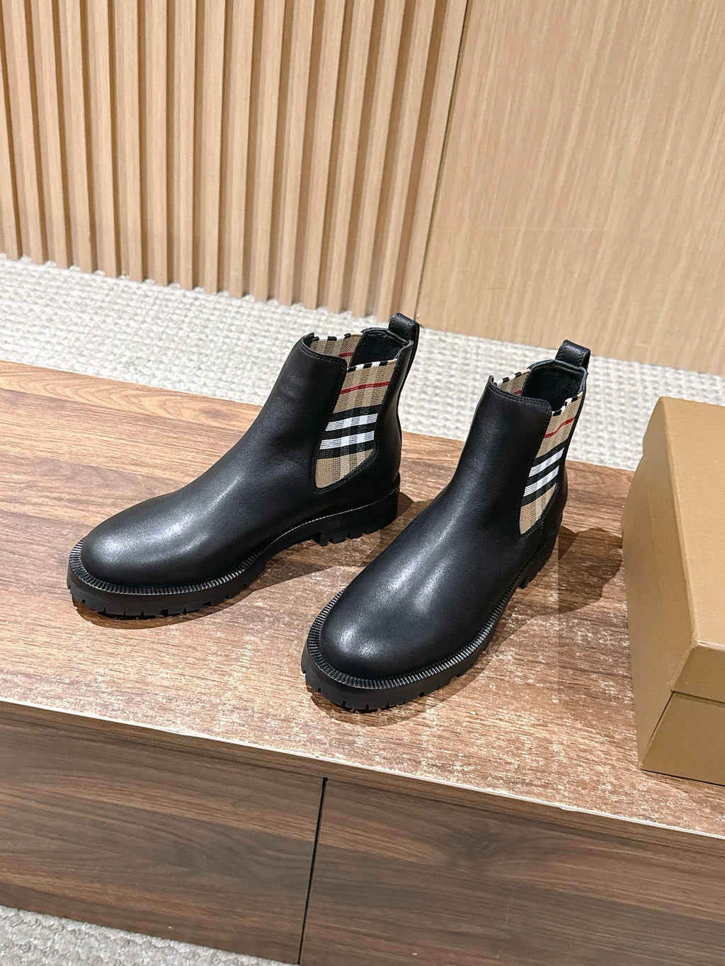 Black leather Chelsea boots with check elastic side panel and treaded rubber sole