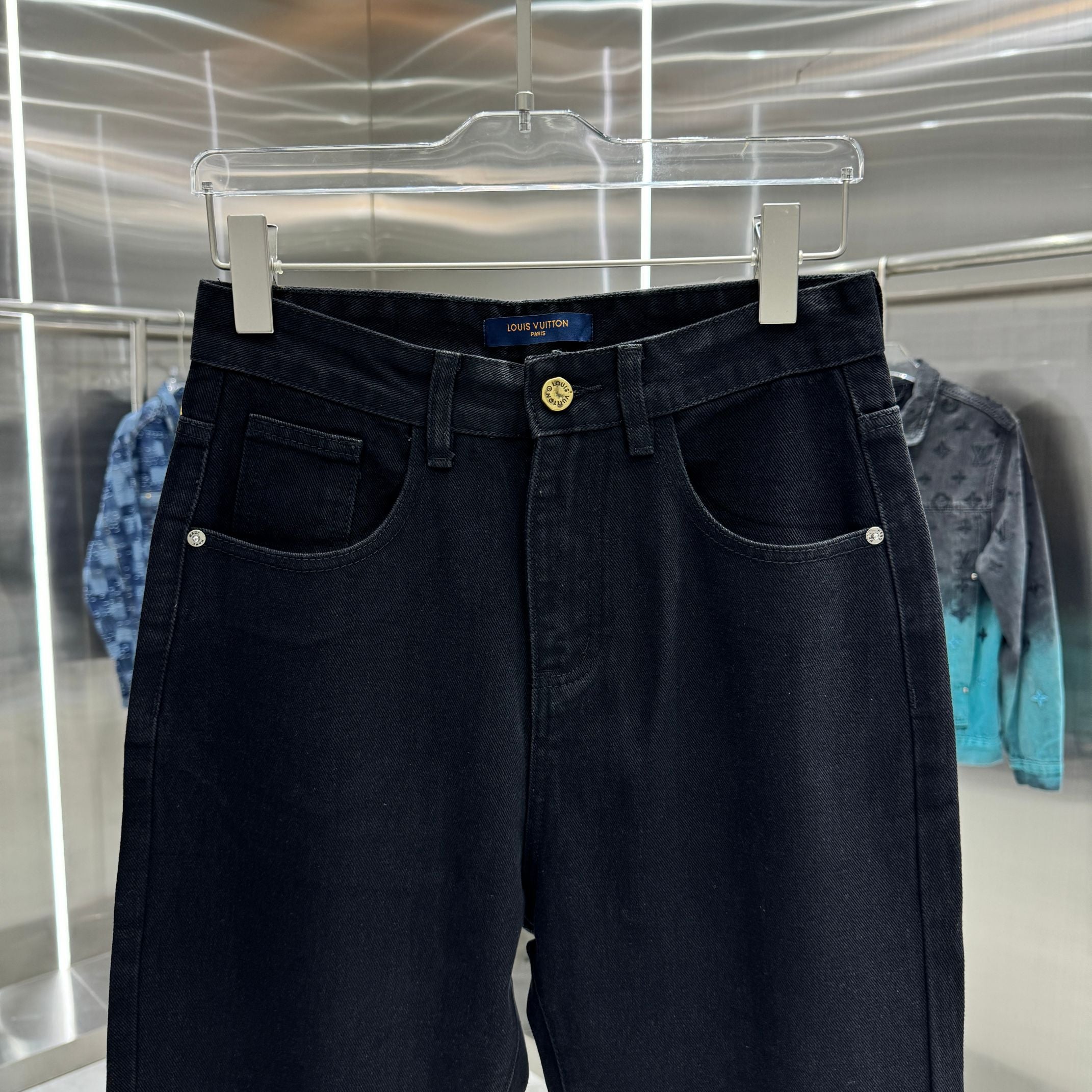 Dark blue denim jeans on hanger with front pockets and gold button
