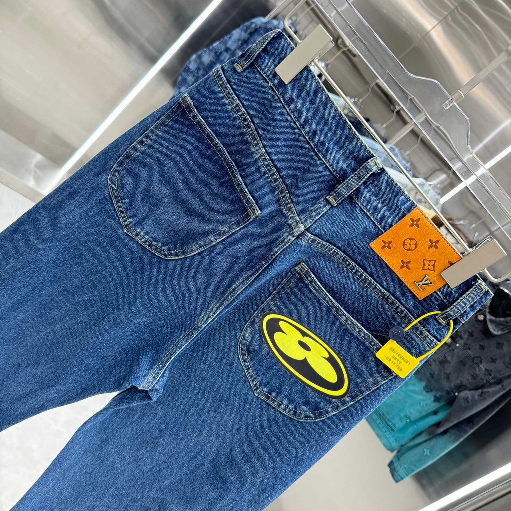 Blue denim Louis Vuitton pants close-up, yellow logo patch on front thigh