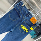 Blue denim Louis Vuitton pants close-up, yellow logo patch on front thigh