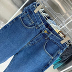 Blue denim Louis Vuitton pants close-up, back patch pockets with gold button