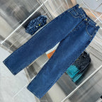 Blue denim Louis Vuitton pants laid out, long straight legs with stitched hems