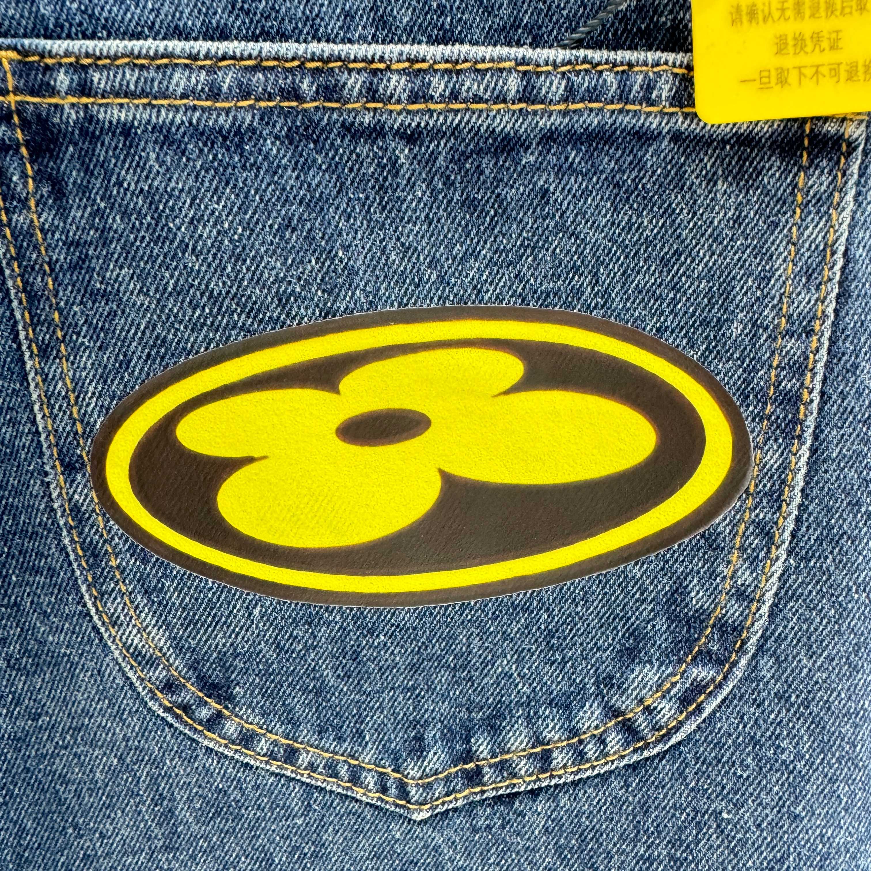 Yellow flower logo patch on blue denim Louis Vuitton pants pocket
