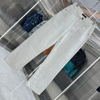 White denim pants laid out, showing front pockets and belt loops