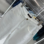 White denim pants with curved front pockets and gold-tone button at waistband