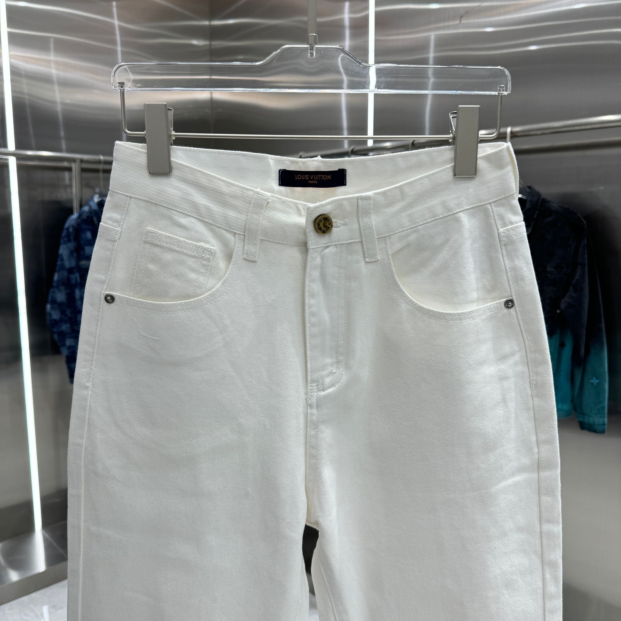 White denim pants with belt loops, two front pockets, and button fly