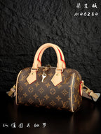 Louis Vuitton monogram handbag angled view with tan handles and dangling strap details