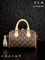 Louis Vuitton monogram handbag front view with tan leather handles and red accents