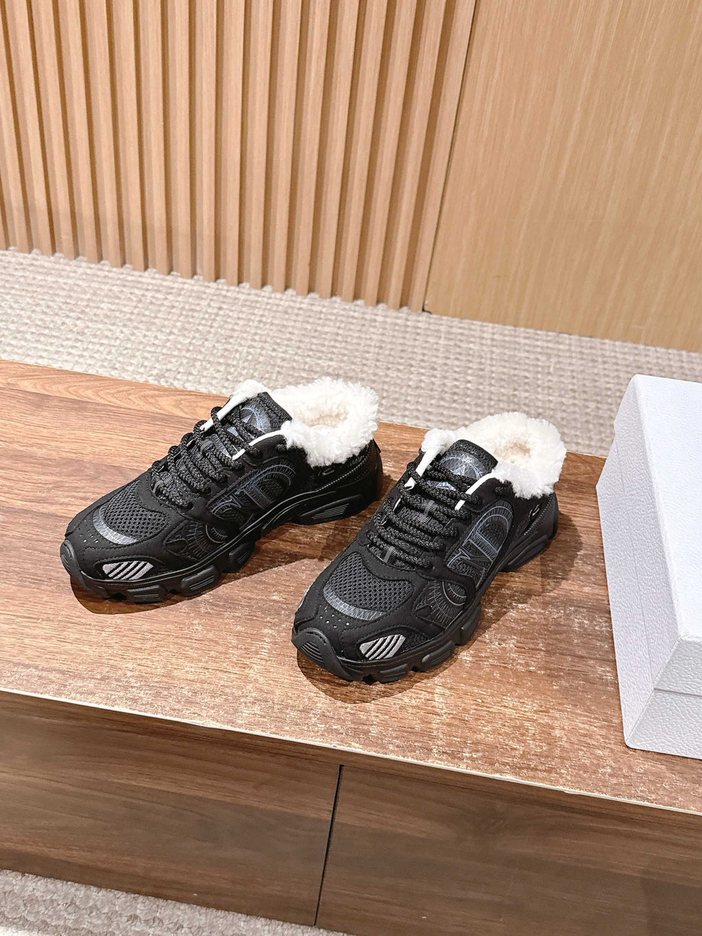 Black unisex sneakers with white sherpa lining, side view, lace-up, thick sole