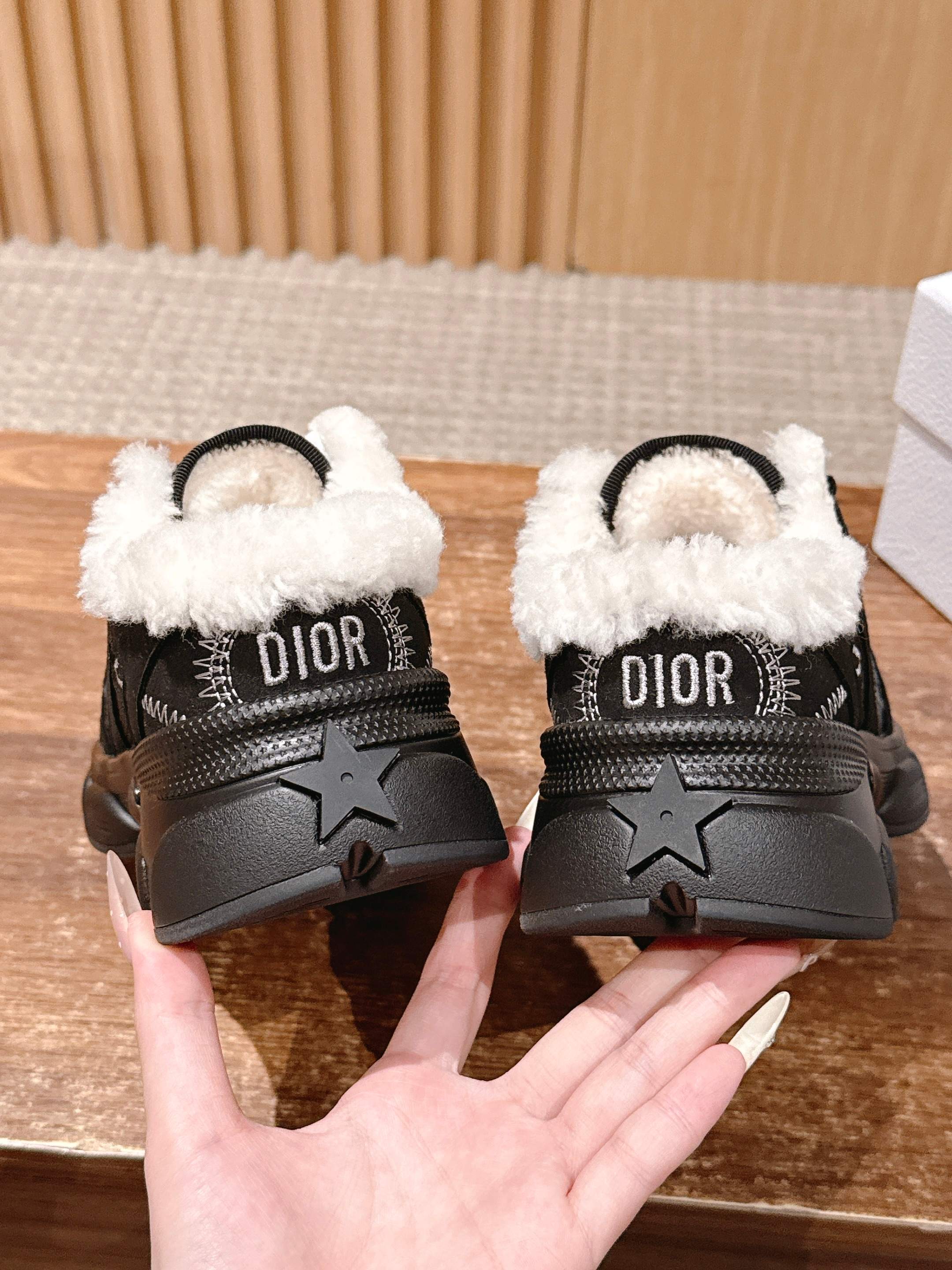 Black unisex sneakers with white sherpa collar, DIOR lettering on heel, star detail
