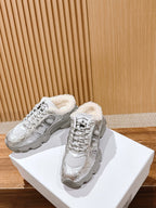 Silver metallic lace-up sneakers with fuzzy lining and star logo, side-by-side on box