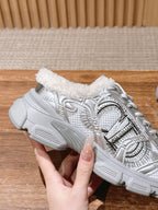 Silver metallic lace-up sneaker held up, faux-fur collar and star side panel visible
