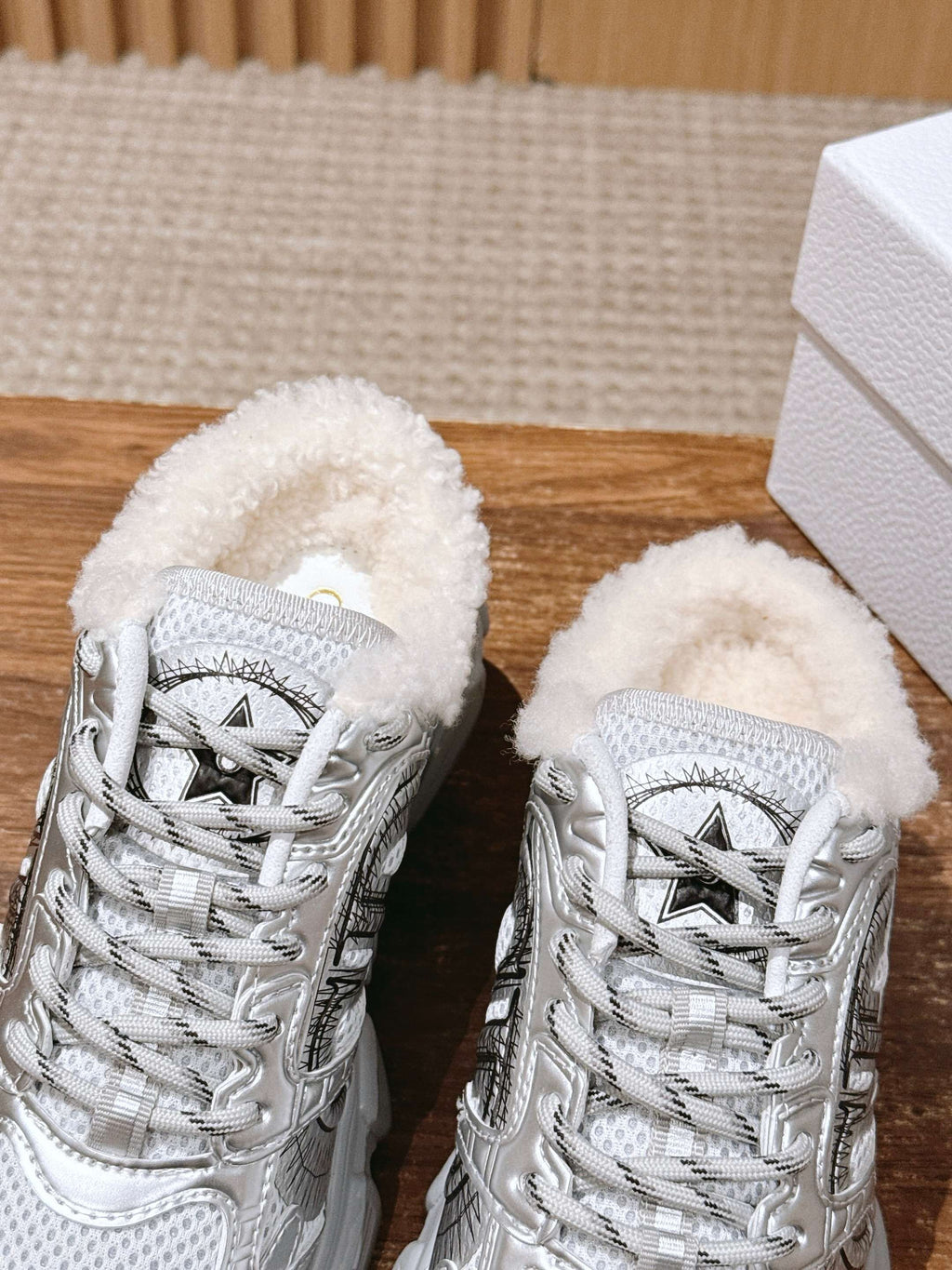 Silver metallic lace-up sneakers with white faux-fur collars, front view of pair