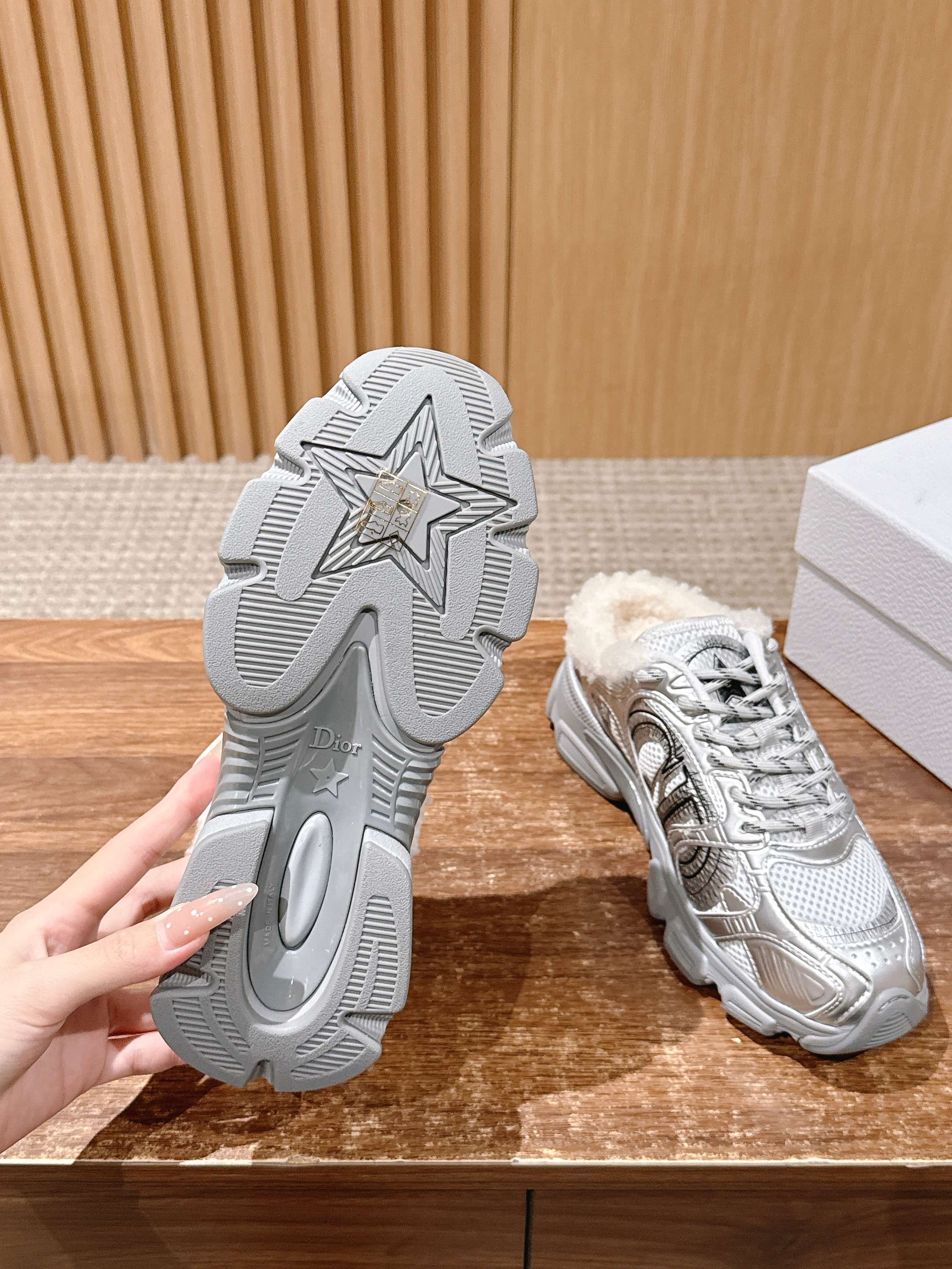 Silver metallic sneaker outsole with star tread, with matching shoe on display