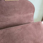 Celine handbag close-up showing textured leather and small gold "CELINE PARIS" stamp