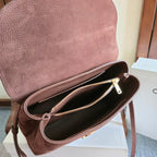 Celine handbag open top with dark interior, gold zipper, and brown leather strap at side