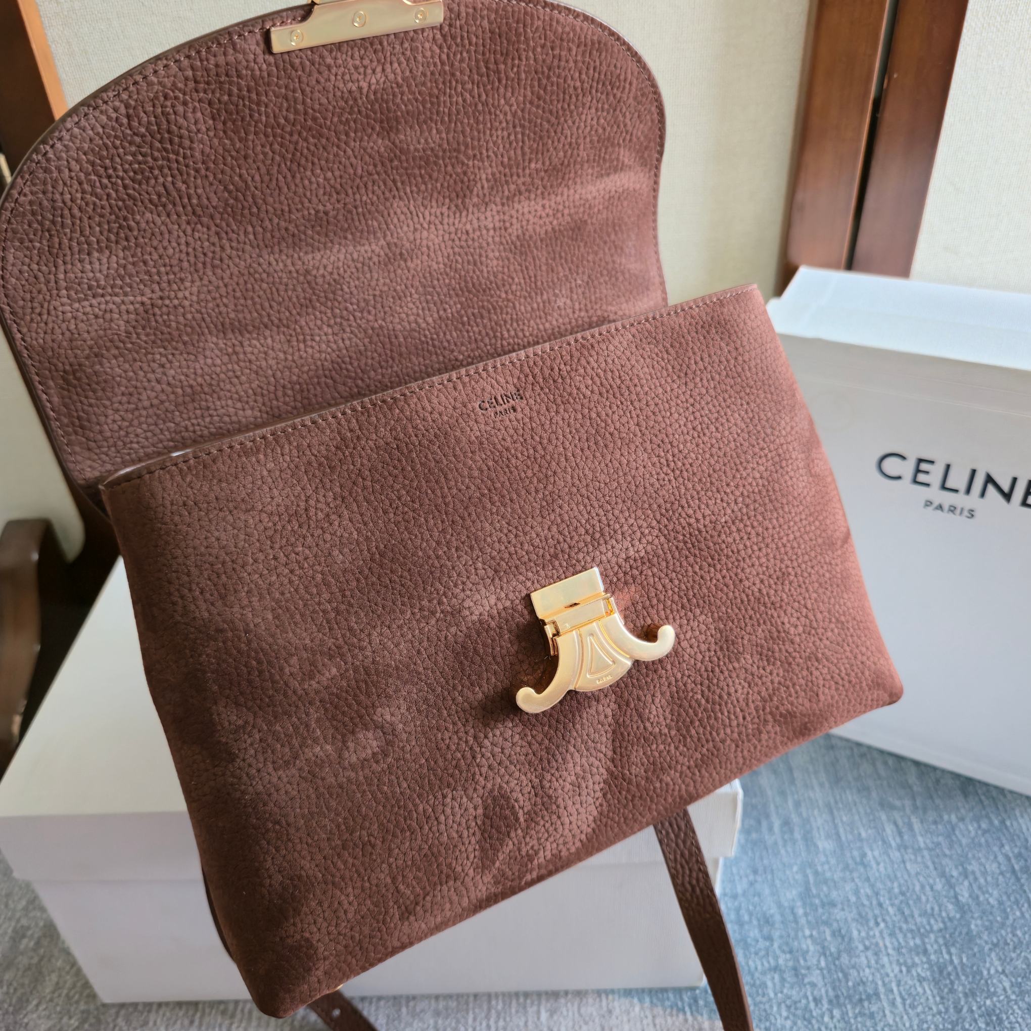 Celine clutch-style bag in dark brown textured leather with small gold logo accent