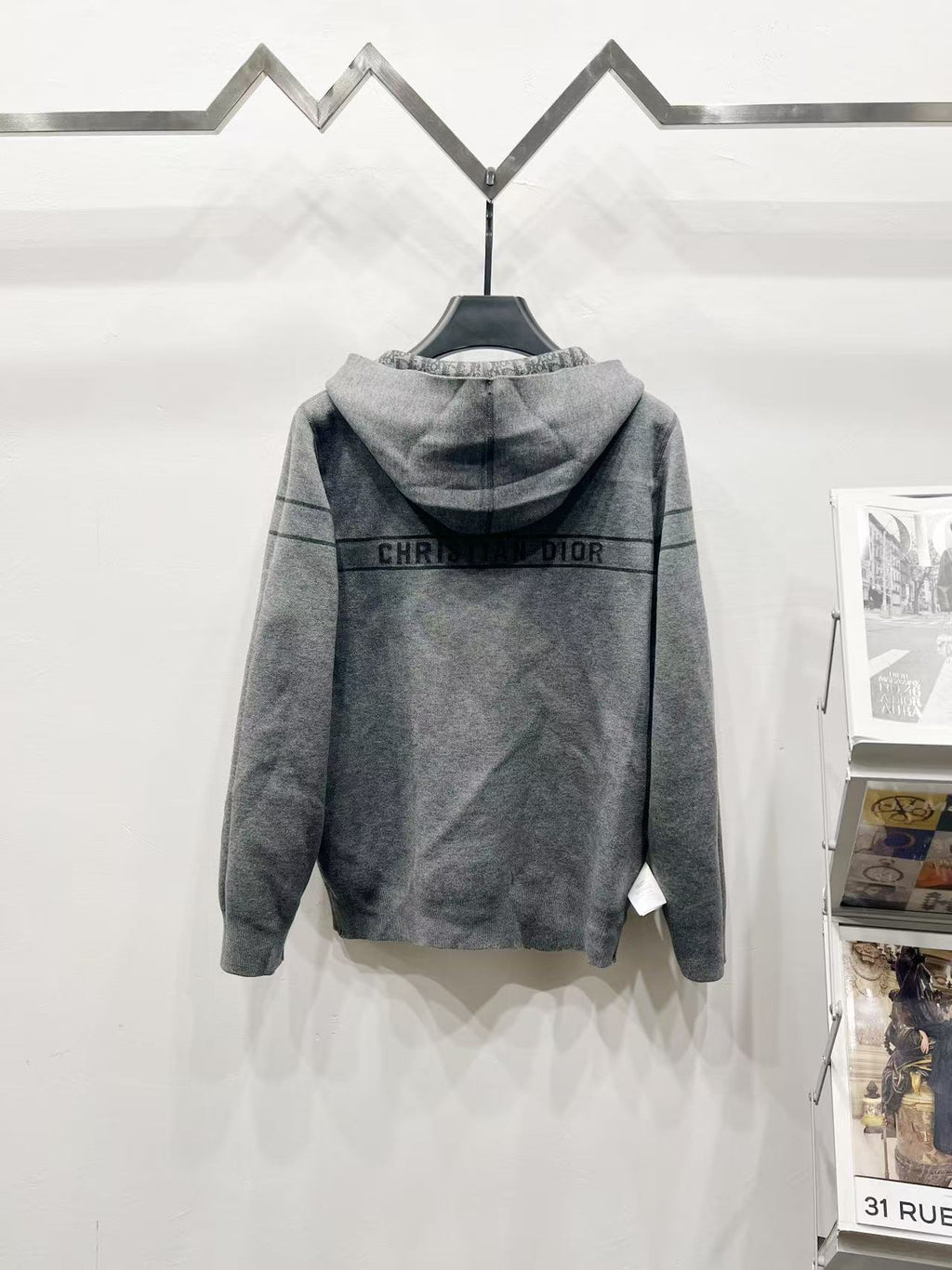 Back view grey hooded zip jacket with repeating Dior-style pattern stripe across shoulders