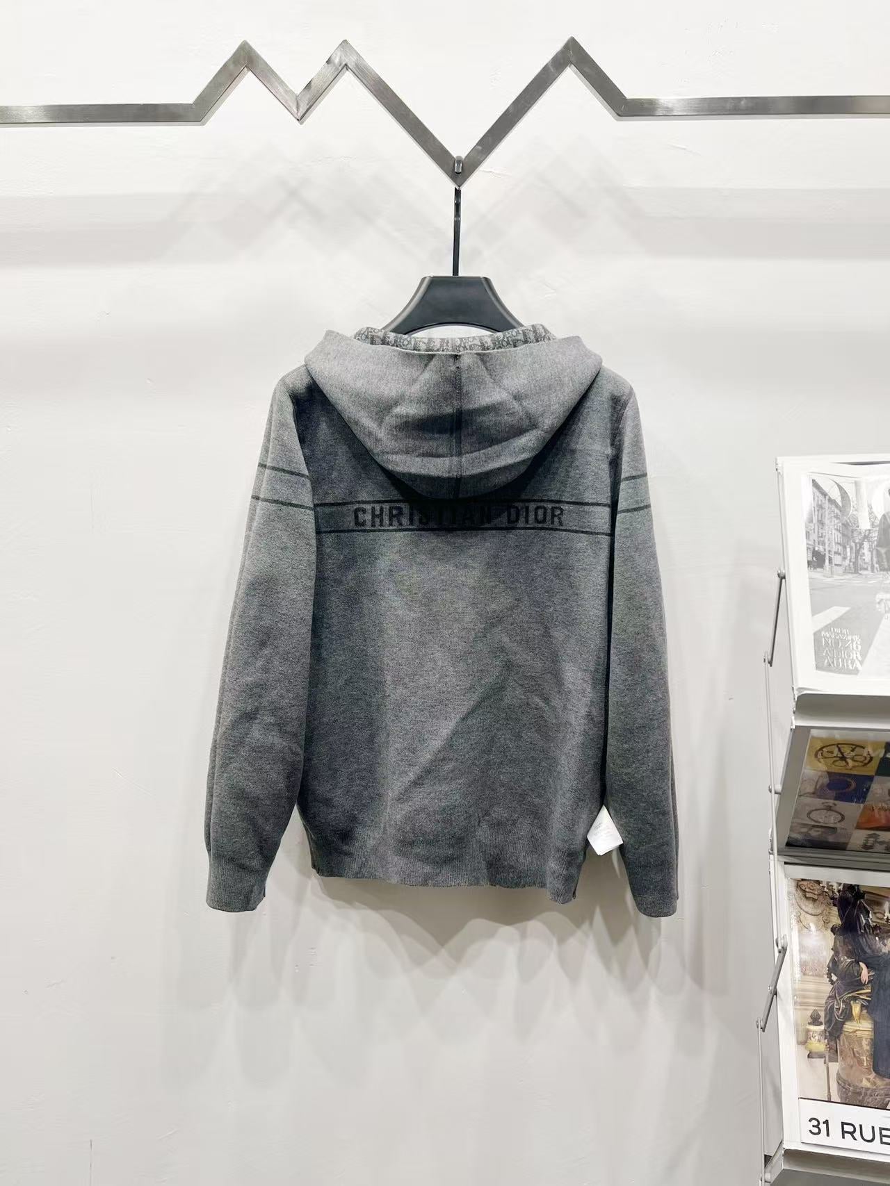 Back view grey hooded zip jacket with repeating Dior-style pattern stripe across shoulders