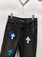 Black denim pants with colorful cross-style patches on the front legs