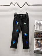 Black denim pants with blue and light-green patch designs, front view