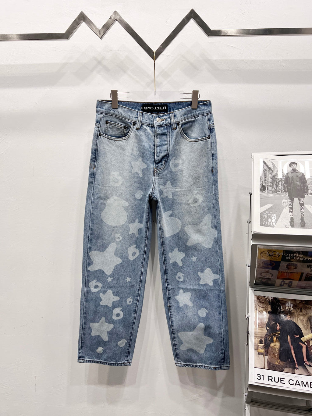 Light blue denim pants with star and heart print, five-pocket style and belt loops