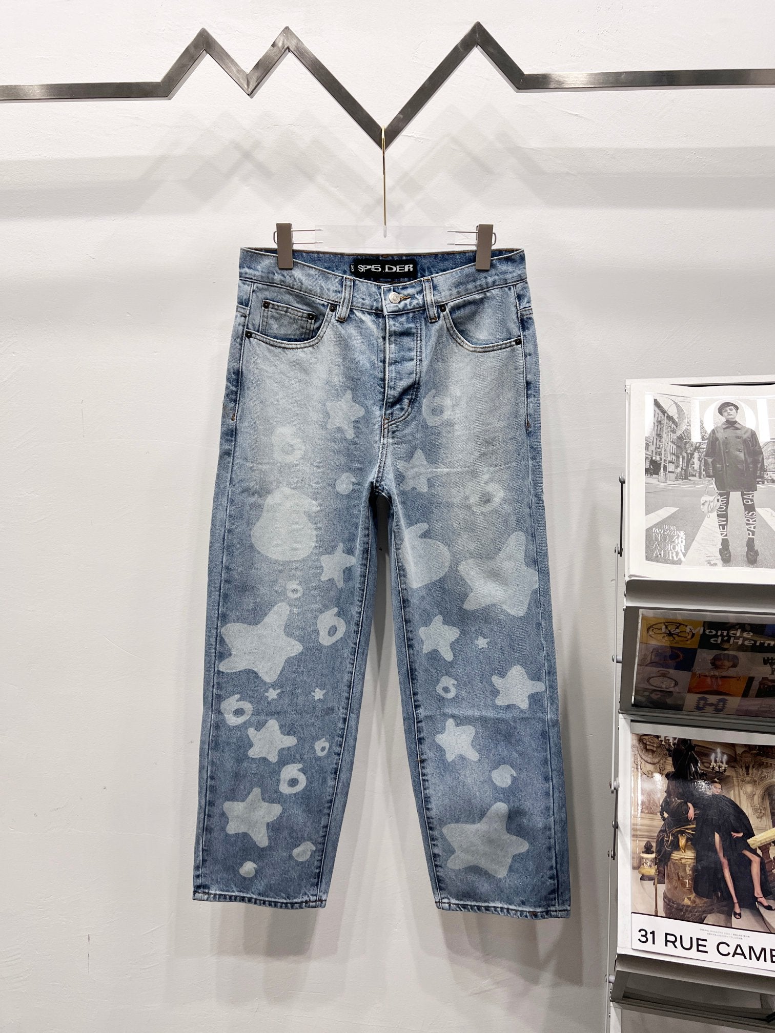 Light blue denim pants with star and heart print, five-pocket style and belt loops