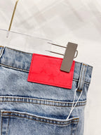Red star-embossed patch detail on light blue denim pants pocket