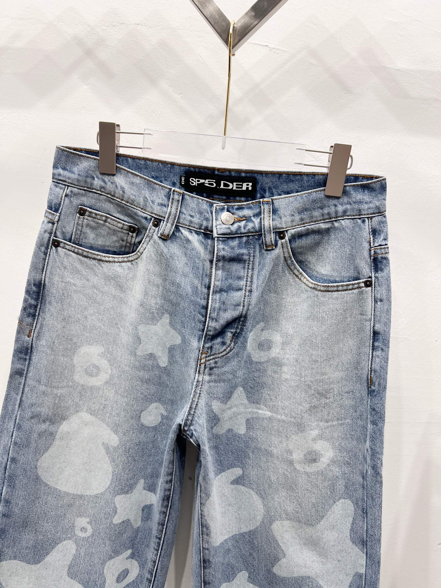 Light blue denim pants with star-and-heart print, front pockets and waistband