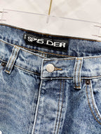 Blue denim pants waistband with logo patch and metal button closure
