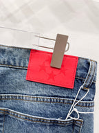 Blue denim pants with red logo patch at waistband and belt loop
