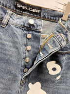 Light blue denim pants with button fly and white graphic patch detail