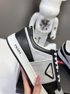 Black and silver low-top sneakers with Prada heel tab and white laces