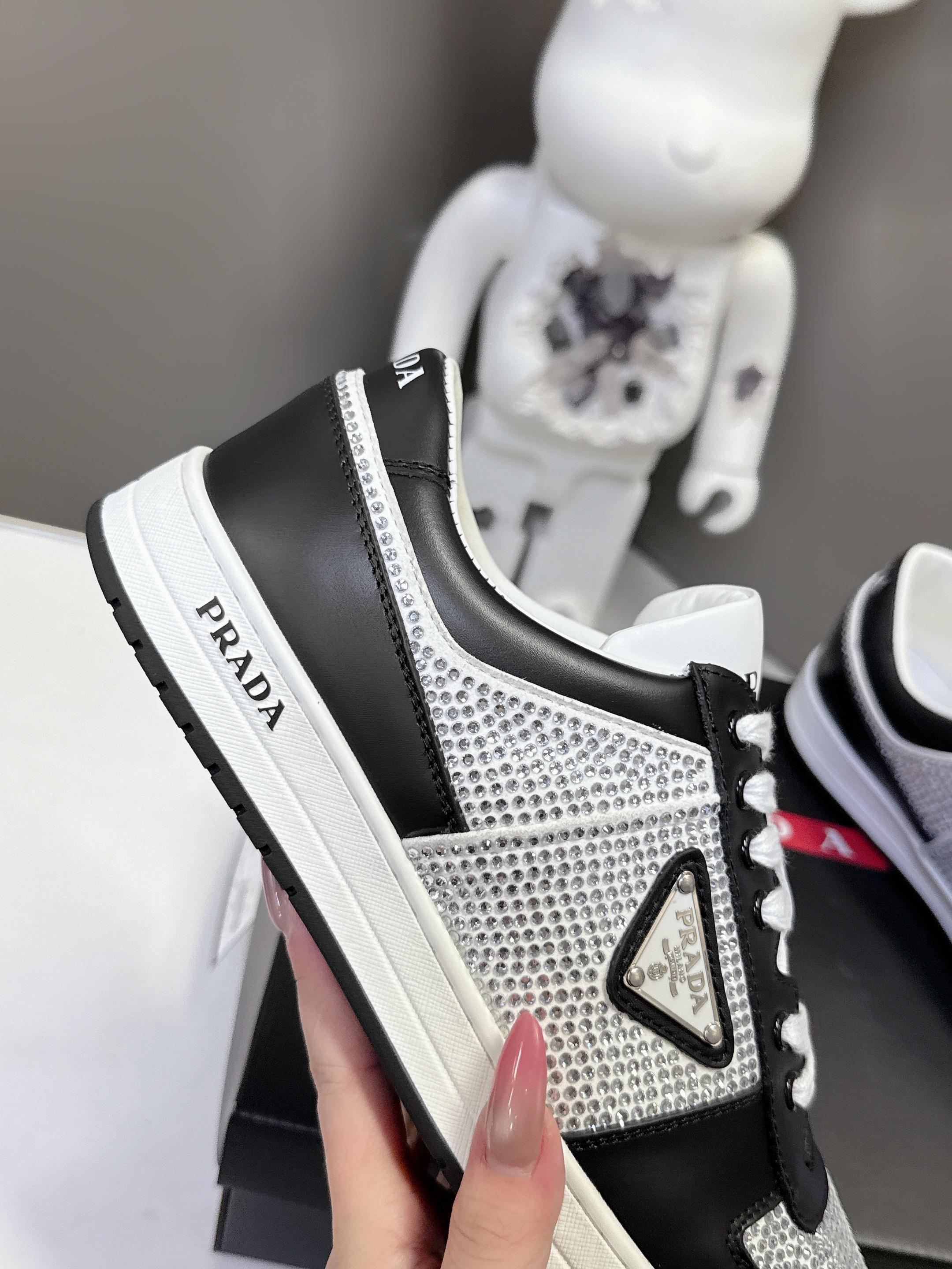 Black and silver low-top sneakers with Prada heel tab and white laces