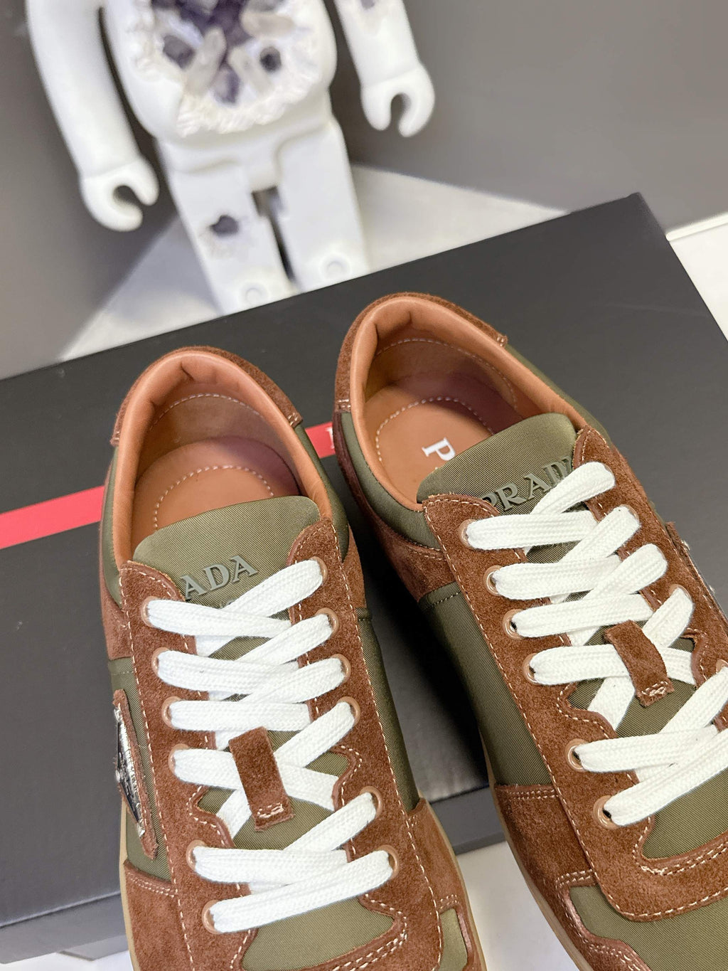 Unisex sneakers front view: brown and olive uppers with white laces and red brand tab