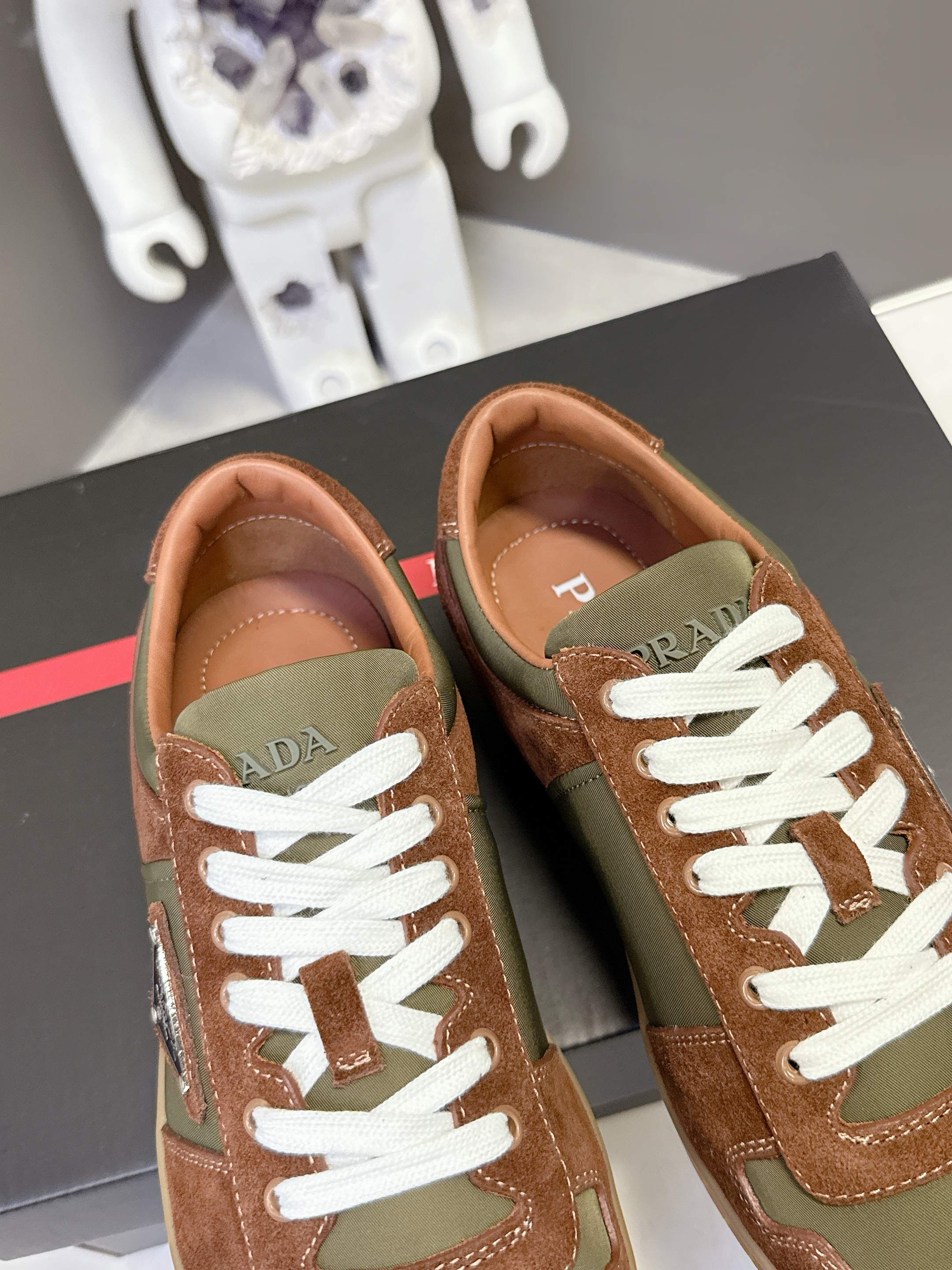 Unisex sneakers front view: brown and olive uppers with white laces and red brand tab