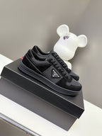 Black Prada unisex sneakers with lace-up front and triangular logo patch on shoebox