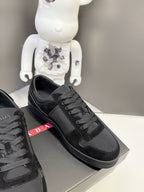 Black Prada unisex sneaker side view with lace-up ties and triangular logo emblem